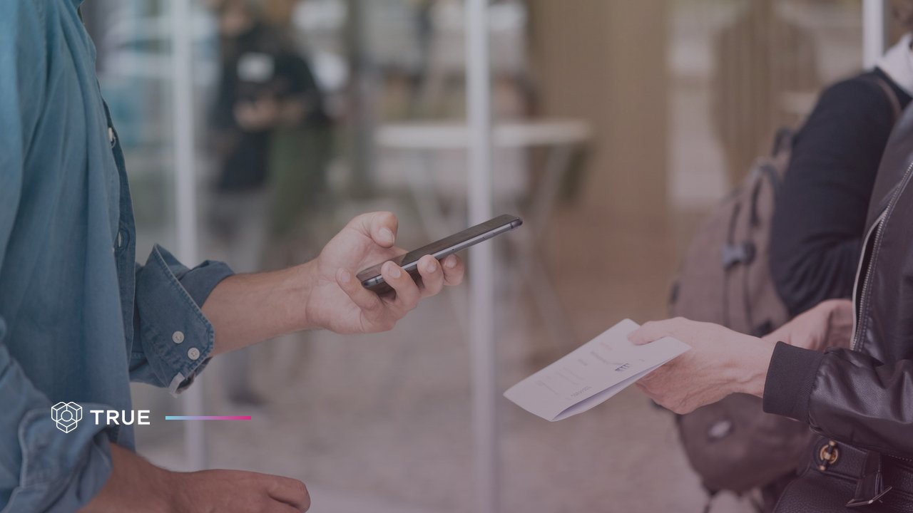 a man scans a printed document held out to him with his phone, the kind of QR check that can return “This QR code is duplicate and only valid for its original printed certificate”